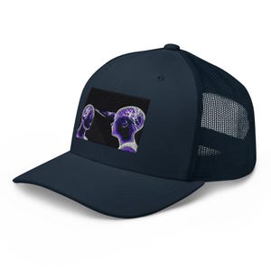 Pode incluir: Um boné trucker azul-marinho com um emblema retangular na frente. O emblema apresenta um gráfico de duas silhuetas de cabeças humanas estilizadas em roxo e branco, com um feixe de luz conectando as duas áreas cerebrais contra um fundo preto.