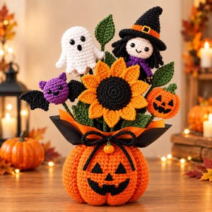 Może przedstawiać: Szydełkowany bukiet na Halloween z pomarańczową podstawą w kształcie dyni, centralnym słonecznikiem, białym duszkiem, fioletowym nietoperzem, czarownicą w czarnym kapeluszu i małą dynią, ozdobiony zielonymi liśćmi oraz czarną kokardą.