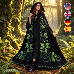 May include: A black hooded cloak featuring intricate green vine and leaf embroidery along the front panels. The garment is floor-length with a textured knit construction, a deep hood, and a scalloped hemline, worn over a simple black dress.