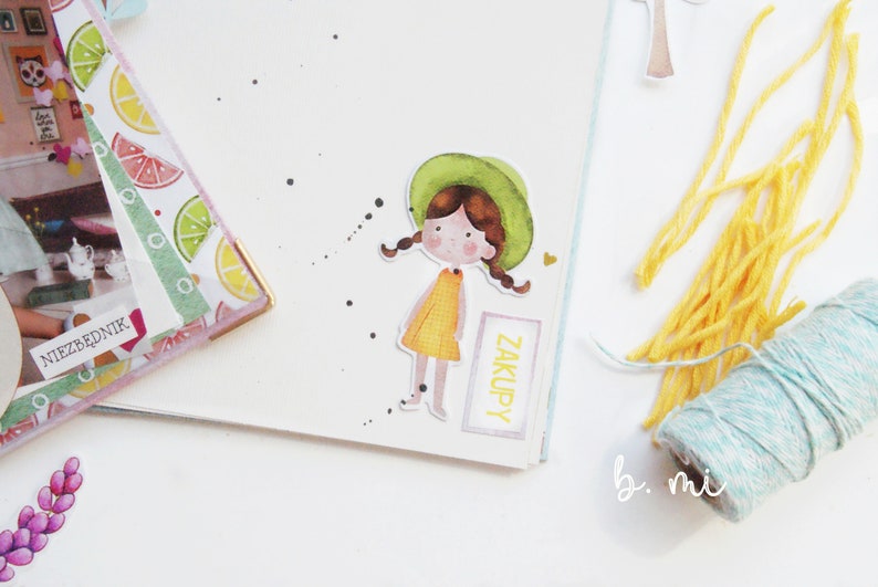 May include: A watercolor illustration of a girl with brown hair wearing a green hat and a yellow dress. The illustration is on a white background with black dots and the word "ZAKUPY" written on a pink rectangle.
