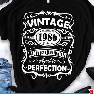 Może przedstawiać: Czarny T-shirt z białym vintage'owym wzorem graficznym. Grafika zawiera napis "Vintage 1986 Original Limited Edition Aged to Perfection".