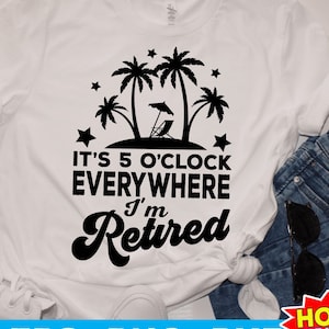 May include: White t-shirt with a black graphic of palm trees, a beach chair, and stars. The text "It's 5 o'clock everywhere I'm retired" is printed in black.