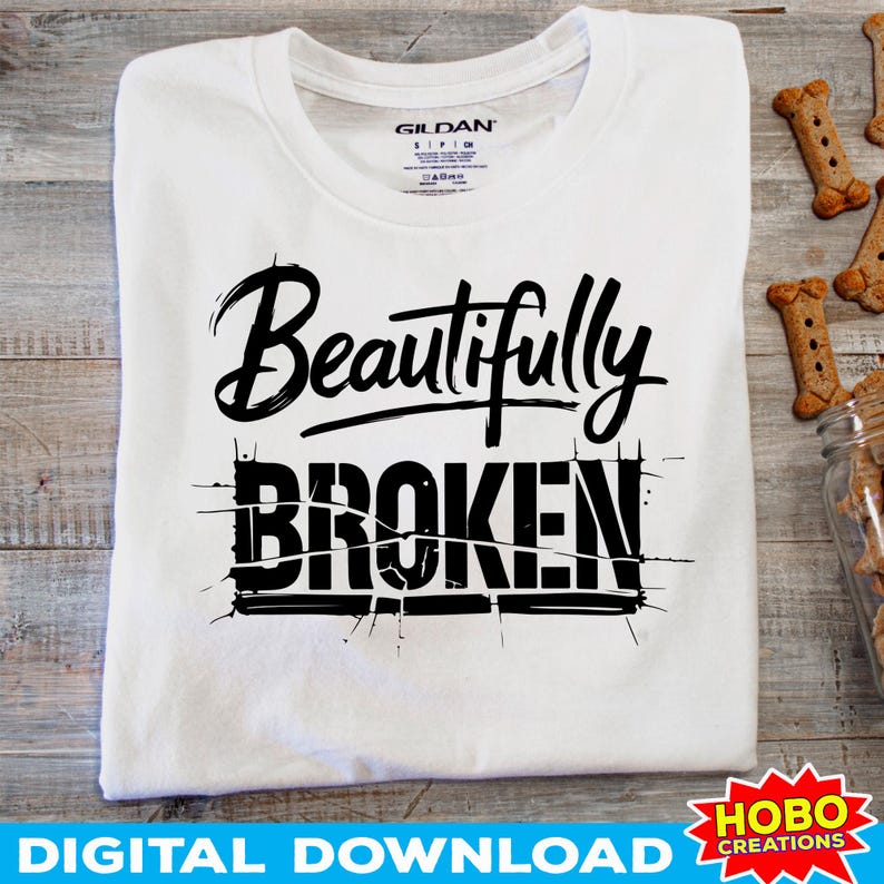 Puede incluir: Camiseta blanca con texto negro que dice "Beautifully Broken" en una fuente estilizada. El texto est&aacute; dividido en dos l&iacute;neas, con "Beautifully" en la l&iacute;nea superior y "Broken" en la l&iacute;nea inferior. El texto est&aacute; rodeado por un borde negro.