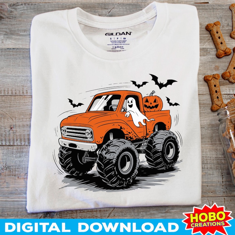 K&ouml;nnte beinhalten: Ein wei&szlig;es T-Shirt mit einem Aufdruck eines orangefarbenen Monstertrucks mit einem Geist am Steuer und einem K&uuml;rbis im Laderaum. Flederm&auml;use fliegen um den Truck herum. Der Text "HOBO CREATIONS" befindet sich in der unteren rechten Ecke.