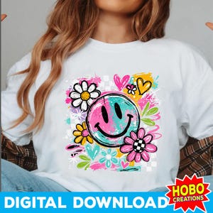 May include: White t-shirt featuring a colorful graphic design. The design includes a split-color smiley face, flowers, hearts, and the text "DIGITAL DOWNLOAD". The design has a retro, groovy aesthetic.