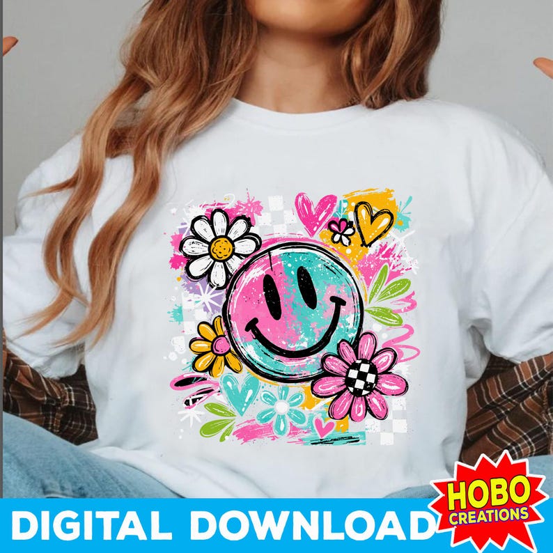 May include: White t-shirt featuring a colorful graphic design. The design includes a split-color smiley face, flowers, hearts, and the text "DIGITAL DOWNLOAD". The design has a retro, groovy aesthetic.