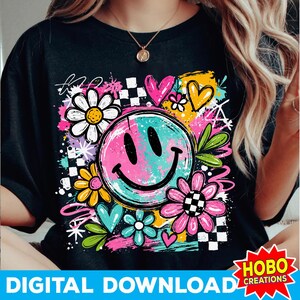 May include: Black t-shirt featuring a colorful graphic design. The design includes a smiley face, flowers, hearts, and a checkered pattern. The words "DIGITAL DOWNLOAD" are at the bottom. The design has a retro, groovy vibe.