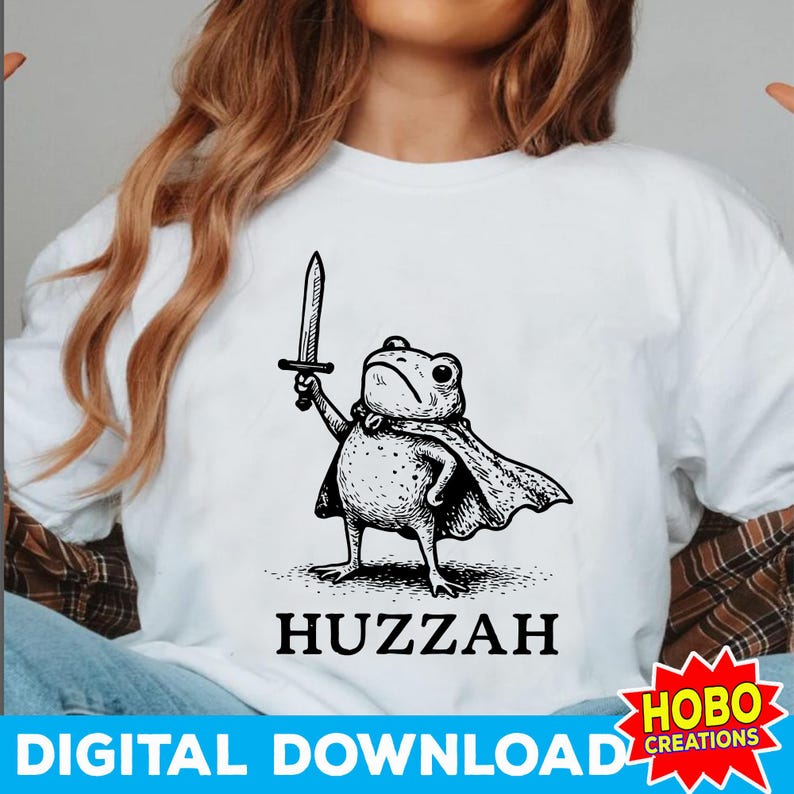 May include: White t-shirt featuring a black and white illustration of a frog wearing a cape and holding a sword. The word "Huzzah" is printed below the frog. The bottom of the shirt has the words "Digital Download".