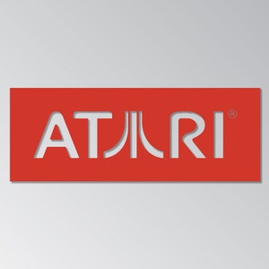 May include: A red rectangular sign with the white text "ATARI" cut out. The Atari logo is a stylized wordmark, with the "A" and "R" having unique shapes. The background is a gradient of light gray.