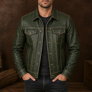 Puede incluir: Una chaqueta de cuero verde bosque oscuro con cuello clásico, mangas largas y cierre frontal de botones. La prenda incluye dos bolsillos en el pecho con solapas abotonadas, detalles de costuras verticales y botones metálicos en el frente.