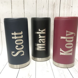 May include: Three personalized stainless steel can coolers. The coolers are in navy blue, black, and burgundy. The names "Scott", "Mark", and "Kody" are engraved on the coolers.