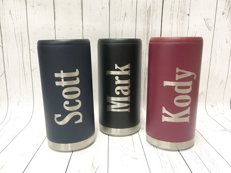 May include: Three personalized stainless steel can coolers. The coolers are in navy blue, black, and burgundy. The names "Scott", "Mark", and "Kody" are engraved on the coolers.