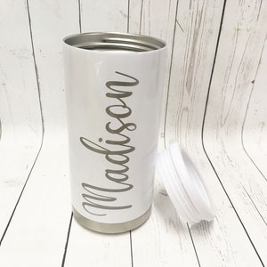 May include: White stainless steel tumbler with a white lid and the name "Madison" written in cursive on the side.