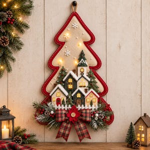 May include: A wall-hanging felt Christmas tree decoration featuring a miniature village scene with illuminated houses, snow-dusted pine trees, and white snowflakes. The base is adorned with a plaid fabric bow, red berries, and pine needles.