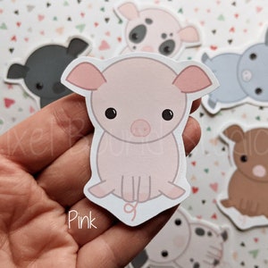 Puede incluir: Un conjunto de seis pegatinas de cerdos, cada una con un color y diseño diferente. Las pegatinas están sobre un fondo blanco con un patrón de corazones rosas. Las pegatinas son perfectas para añadir un toque de fantasía a tu agenda, portátil o botella de agua.