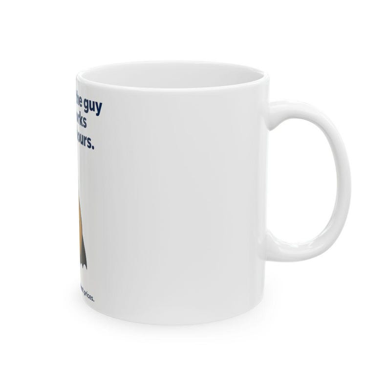 May include: A white ceramic mug featuring a graphic of a person in a dark cape and the text: I am the guy who works long hours. The design includes dark blue lettering and a stylised figure with a brown and black cape on the side of the mug.