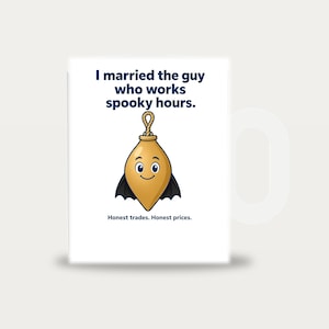 May include: A white ceramic mug featuring the text I married the guy who works spooky hours. at the top and Honest trades. Honest prices. at the bottom. In the centre is a cartoon illustration of a gold plumb bob with bat wings and a face.