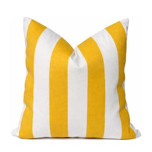 May include: A square decorative pillow with a bright yellow and white striped pattern. The pillow has a soft, textured appearance and is designed for home decor.