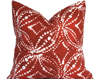 May include: A square throw pillow featuring a deep red background with a repeating white pattern composed of small dots. The design consists of interconnected diamond and oval shapes formed by these white dots, creating a symmetrical geometric motif across the entire surface of the pillow cover.