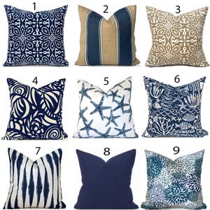 May include: A collection of nine square throw pillows featuring various patterns including navy blue and white geometric designs, beige and blue stripes, starfish prints, marine life motifs, vertical blue and white stripes, solid navy, and floral patterns.