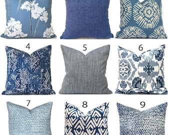 May include: A collection of nine square throw cushions featuring various blue and white patterns. The designs include floral motifs, solid textured fabrics, geometric shapes, ikat-style prints, and dotted textures, all arranged in a three-by-three grid.
