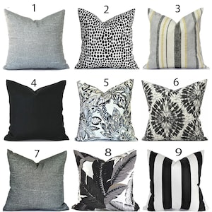May include: A collection of nine square throw pillows featuring various patterns and textures. Designs include solid gray, black and white animal print, striped with yellow accents, solid black, floral, tie-dye, dark gray, tropical leaf, and black and white stripes.