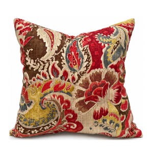 May include: Square decorative pillow with a vibrant floral pattern in shades of red, brown, yellow, and blue. The pillow features a detailed paisley design, adding a touch of elegance. The pillow is a square shape.