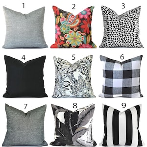 May include: Nine decorative cushions in various designs. Cushions include solid grey, floral, black and white polka dot, solid black, floral, black and white buffalo check, grey textured, black and white leaf, and black and white striped patterns.