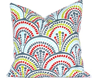 May include: A square throw pillow featuring a repeating fan-shaped pattern composed of small dots in shades of red, lime green, light blue, and dark gray. The design is arranged in overlapping arcs against a white background, creating a vibrant, multi-colored geometric motif across the entire surface of the fabric cover.