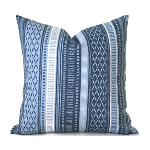 May include: Blue and white striped throw pillow with a geometric pattern. The pillow is made of a soft, woven fabric.