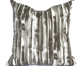May include: A decorative throw pillow with a gray and white striped pattern. The stripes are abstract and resemble brushstrokes.