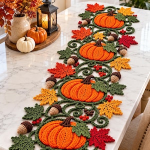 Puede incluir: Un camino de mesa largo tejido a ganchillo con un patrón repetitivo de calabazas de color naranja brillante, hojas verde oscuro, pequeñas bellotas marrones y racimos de bayas rojas. El diseño intrincado está unido por enredaderas de ganchillo verde oscuro.