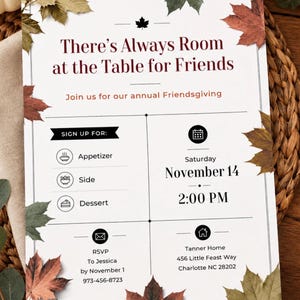 May include: A white Friendsgiving invitation card featuring autumn maple leaves in shades of red, orange, and green. The text reads There's Always Room at the Table for Friends, Join us for our annual Friendsgiving, Saturday November 14, 2:00 PM.