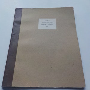 May include: A brown cardboard book with a brown spine and a white label on the front. The label reads "The English Saints" by "Dom Bede Camm" and "1932".