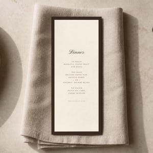 May include: A rectangular dinner menu card with a dark brown border and cream-colored center. The text reads: Dinner, To Begin Burrata, Stone Fruit and Basil, The Main Braised Short Rib, Potato Puree or Halibut, Beurre Blanc, To Finish Olive Oil Cake, Crème Fraiche, The Fifth of June.
