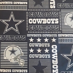May include: Black fabric with a repeating pattern of white stars, white 'COWBOYS' text, and a silver football helmet with a white star.