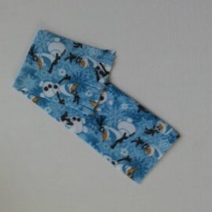 May include: Blue fabric with a repeating pattern of Olaf and Sven from the movie Frozen. The fabric is folded in half.