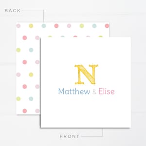 May include: A white card with a yellow letter N, the words "Matthew & Elise" in blue and pink, and a polka dot pattern on the back.