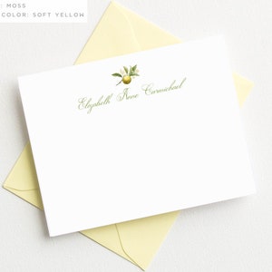 May include: A white stationery card with a green lemon illustration and the text "Elizabeth Anne Carmichael" in green cursive script.