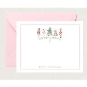 May include: A white card with a pink border and a pink envelope. The card features a watercolor illustration of a ballerina, a nutcracker, a Christmas tree, and a mouse. The text "EYLA CECELIA" is printed at the bottom of the card.