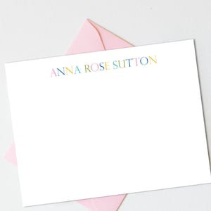 May include: White stationery with a pink envelope. The stationery has the name "ANNA ROSE SUTTON" printed in colorful letters.