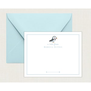 May include: A white card with a blue border and a small illustration of a puffin. The text "a note from Rebecca Sutton" is printed in blue below the puffin.