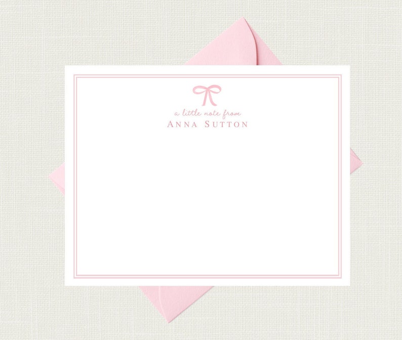 Pode incluir: Um cart&atilde;o de papelaria branco com um la&ccedil;o de fita rosa e o texto "a little note from ANNA SUTTON".