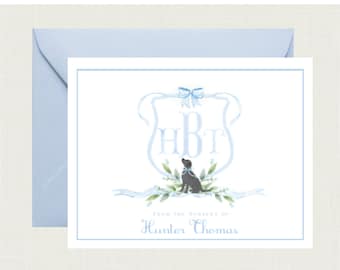 May include: A blue and white watercolor monogram with the initials "HBT" and a black dog sitting in front of it. The monogram is surrounded by a blue ribbon and green leaves. The text "From the nursery of Hunter Thomas" is below the monogram.