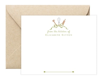 May include: White stationery card with a green ribbon and kitchen utensils, including a whisk, rolling pin, and wooden spoon. The text "from the kitchen of Elizabeth Sutton" is printed in green below the image.