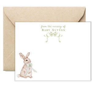 Puede incluir: Una tarjeta blanca con un dise&ntilde;o de cinta verde y el texto "from the nursery of Baby Sutton". Una ilustraci&oacute;n de acuarela de un conejo marr&oacute;n con un lazo verde se encuentra en la esquina inferior derecha.
