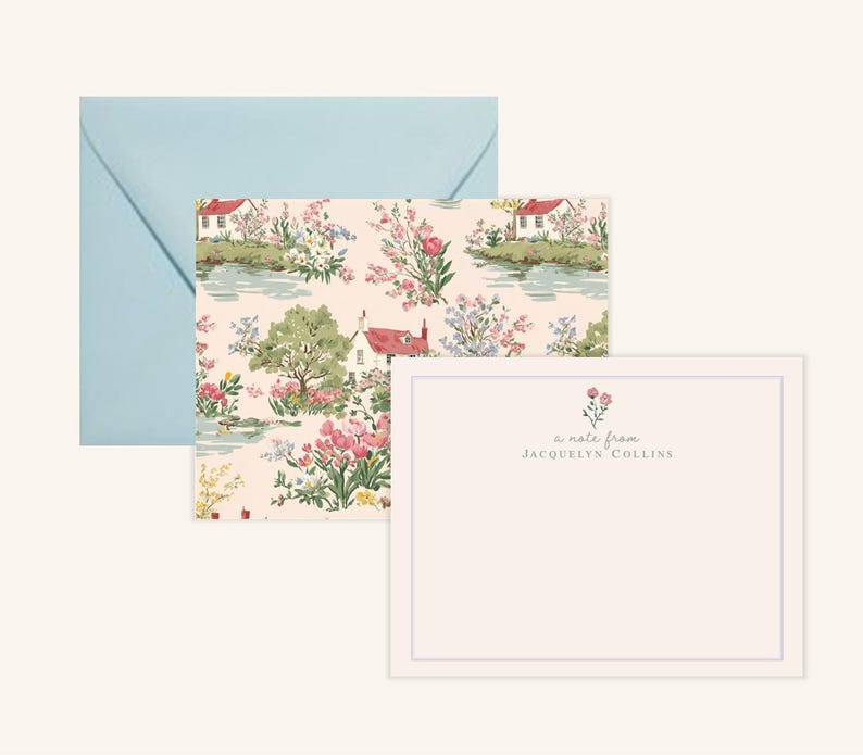 May include: Stationery set featuring a light blue envelope, a patterned card with a landscape design, and a blank card with a floral accent. The patterned card showcases a scenic view with houses, trees, and flowers. The blank card has the text "a note from Jacquelyn Collins."