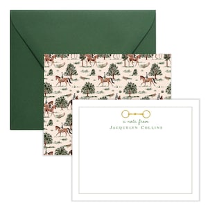 May include: A white note card with a green border and a gold horse bit design. The text "a note from JACQUELYN COLLINS" is printed on the card. The card is accompanied by a green envelope with a pattern of horses and riders.