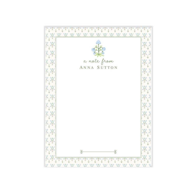 May include: A white notepad with a blue and green floral border. The notepad has a floral illustration and the text "a note from ANNA SUTTON" at the top.