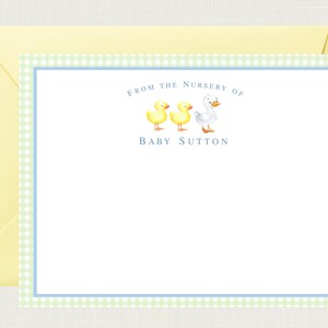 May include: A light blue and green gingham border surrounds a white card with the text "From the Nursery of Baby Sutton" and a picture of three ducklings, two yellow and one white.